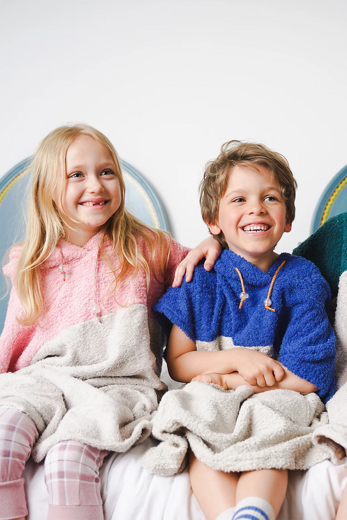 Kinder tragen weiche Badeponchos aus Baumwolle in bunten Farben