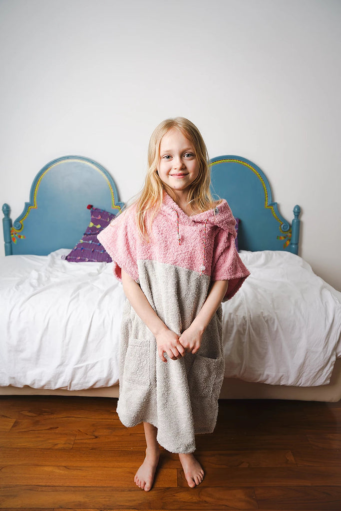 Kind trägt Badeponcho für Mädchen in rosa aus weicher Baumwolle