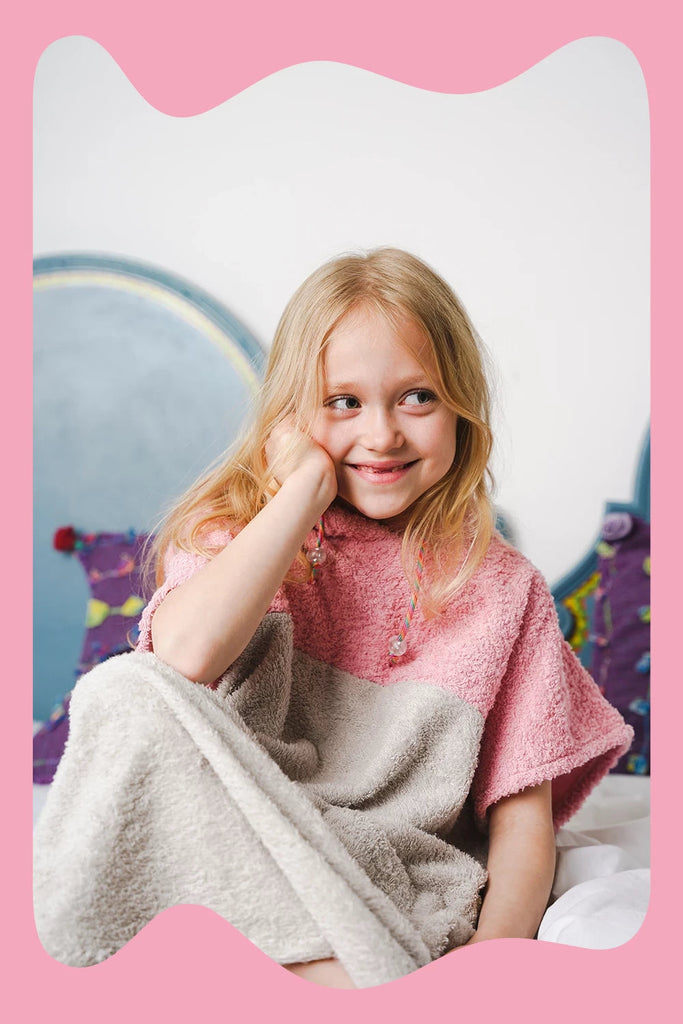 Mädchen trägt rosa Badeponcho für Kinder aus Baumwolle